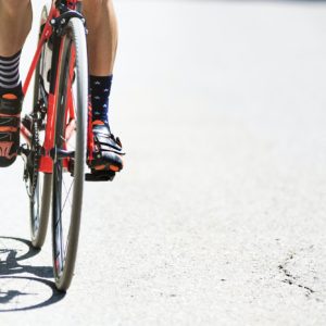 Close-up of the foot of a young man cycling on the road